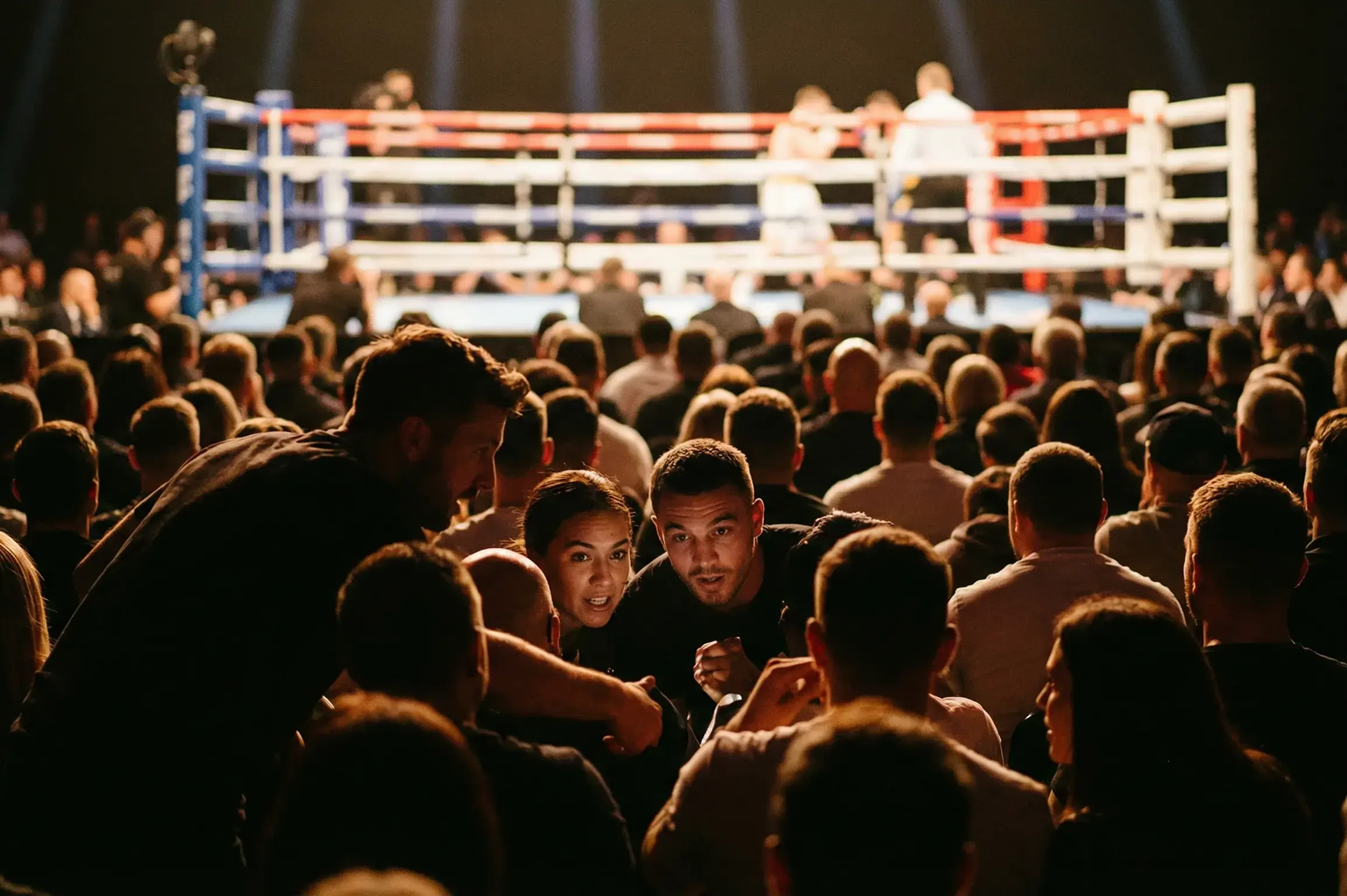 Spectateurs concentrés regardant un combat de boxe en direct dans une salle